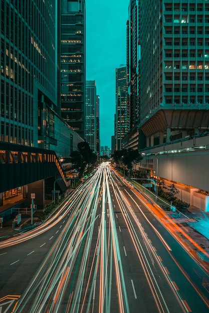 Des traces de lumière sur la route au milieu des bâtiments de la ville la nuit