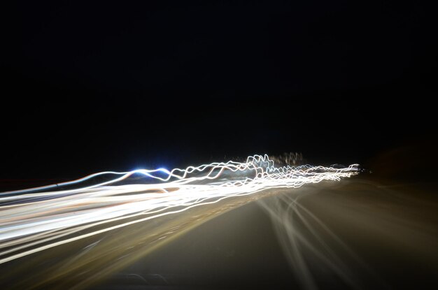 Photo des traces de lumière sur la route contre le ciel la nuit