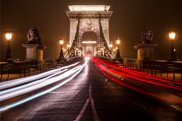 Photo des traces de lumière sur la route la nuit.