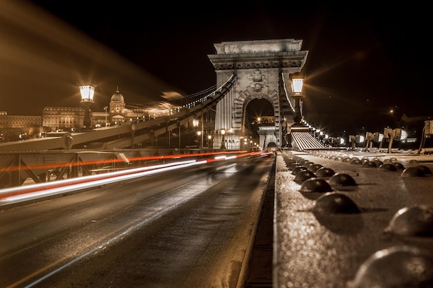 Photo des traces de lumière sur la route la nuit.