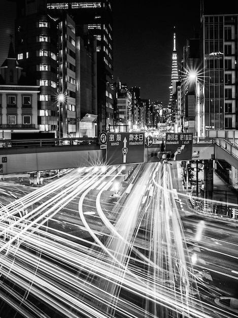 Photo des traces de lumière sur la route près des bâtiments de la ville la nuit