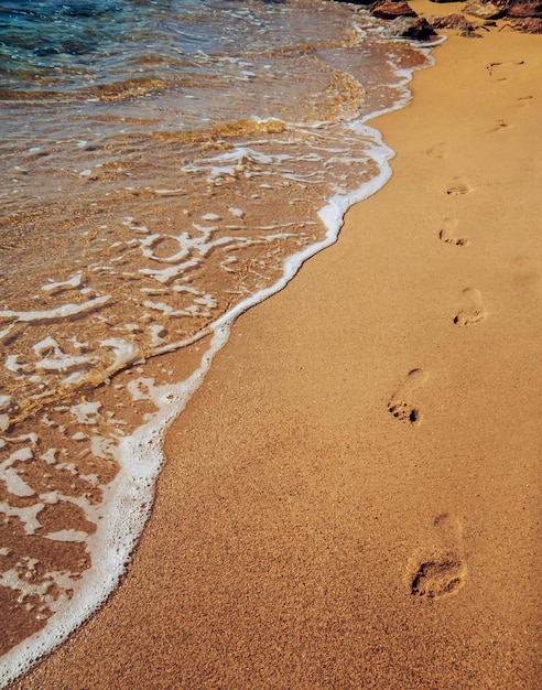 Traces d'un pied sur du sable jaune sur l'ile de Skiathos plage de Koukounaries en bord de mer