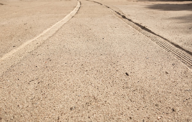 Les traces de pneus de voiture sur le sable de la plage en perspective