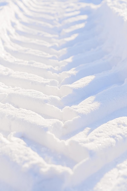 Traces de roues de tracteur dans la neige L'empreinte de la bande de roulement des équipements des services municipaux lors du déneigement