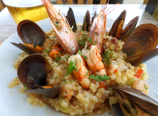 Trachanotto aux fruits de mer à la grecque (Frumenty) avec moules et crevettes