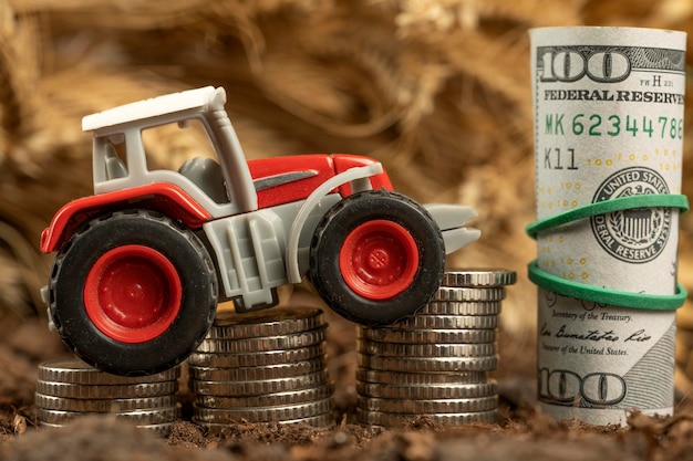 Tracteur avec de l'argent sur fond d'épillets de blé Exportation de céréales et agriculture Hausse des prix des produits agricoles