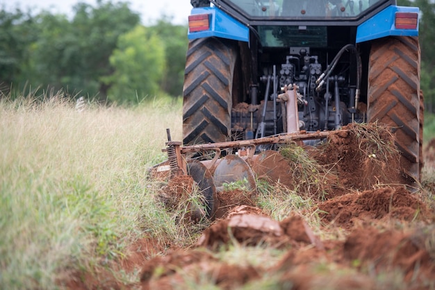 Un tracteur bleu travaillant sur des terres agricoles