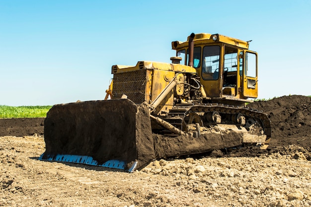 Tracteur bulldozer jaune debout dans un champ