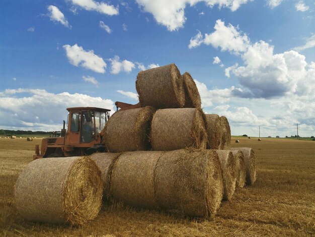 Un tracteur avec une charge de balles de foin au milieu