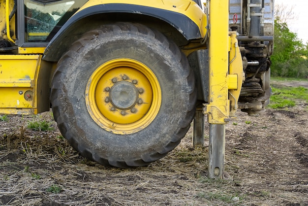 Tracteur jaune sur le terrain debout sur ses pattes arrière.