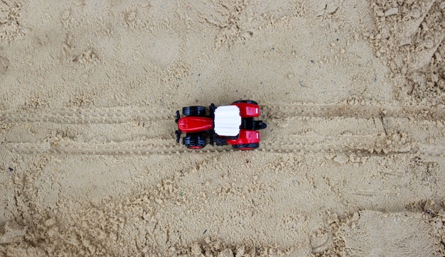 Tracteur jouet avec du sable. le concept de construction