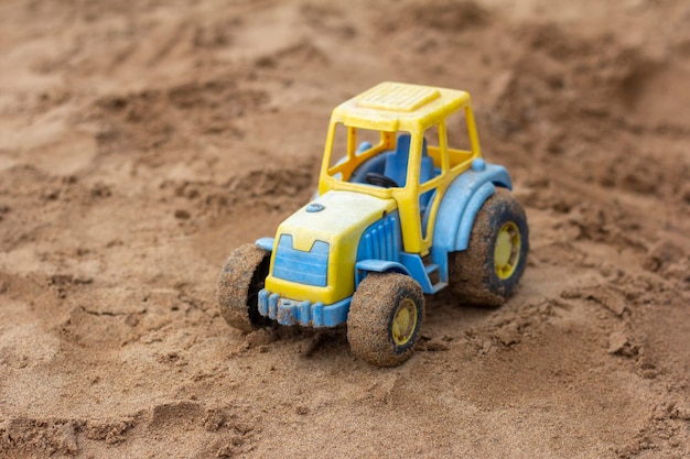 Tracteur jouet pour enfants sur le bac à sableUn jouet oublié