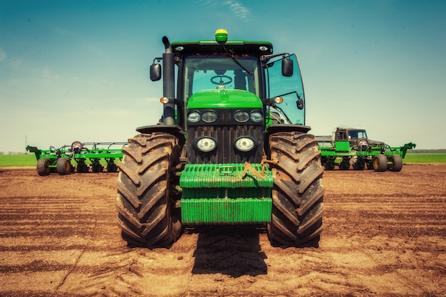 Photo tracteur labourant le champ de la ferme en préparation de la plantation de printemps