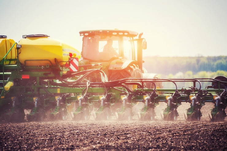 Photo tracteur labourant le champ de la ferme en préparation de la plantation de printemps