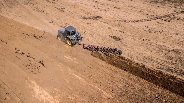 Tracteur labourant le champ vue de dessus photographie aérienne avec drone