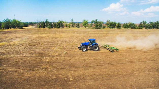 Un tracteur labourant et semant dans le champ