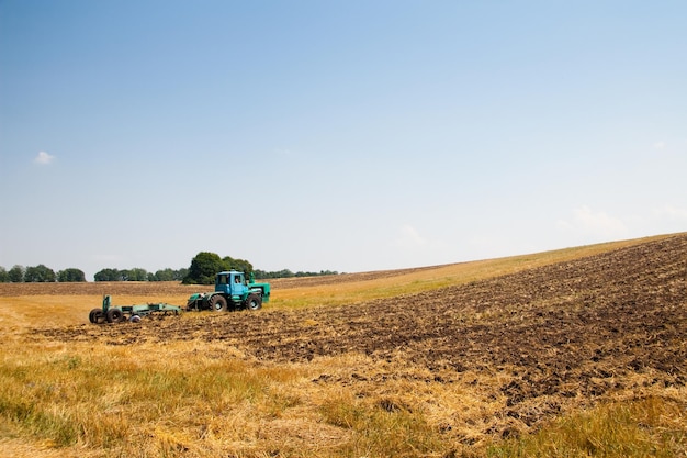 Tracteur moderne sur le terrain avec complexe pour le labour Le concept de travail dans une industrie des champs et de l'agriculture