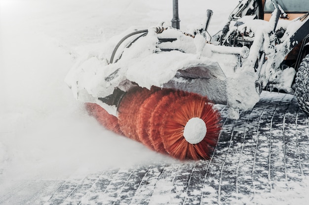 Le tracteur nettoie la route de la neige après le blizzard ou la neige épaisse. Nettoyage ou déneigement