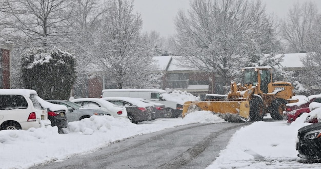 Le tracteur nettoie le véhicule de déneigement en enlevant la neige après de fortes chutes de neige