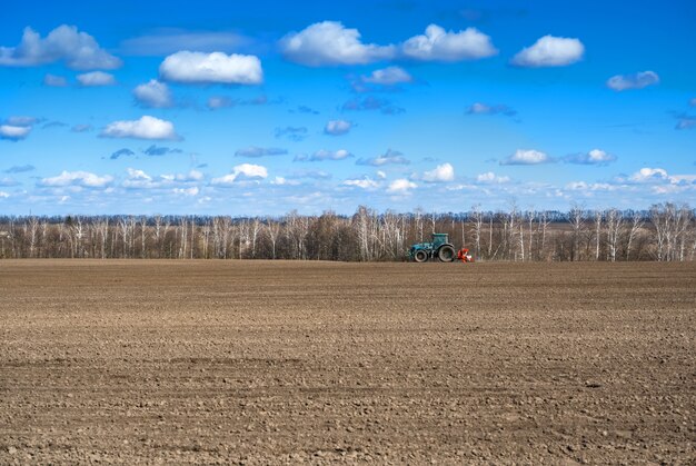 Tracteur avec semoir sur le terrain au début du printemps