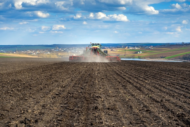 Tracteur avec semoir sur le terrain au début du printemps