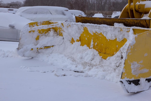 Tracteur de service municipal d'hiver déblayant la rue dans la neige sur la chaussée après de fortes chutes de neige