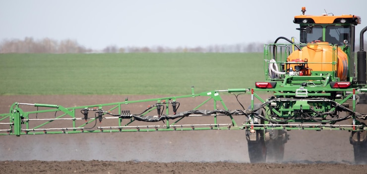 Photo le tracteur traite le sol avec des pesticides