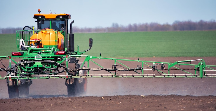 Photo le tracteur traite le sol avec des pesticides