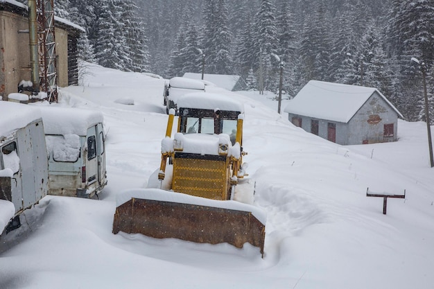 Le tracteur et les vieux véhicules sont recouverts d'une épaisse couche de neige