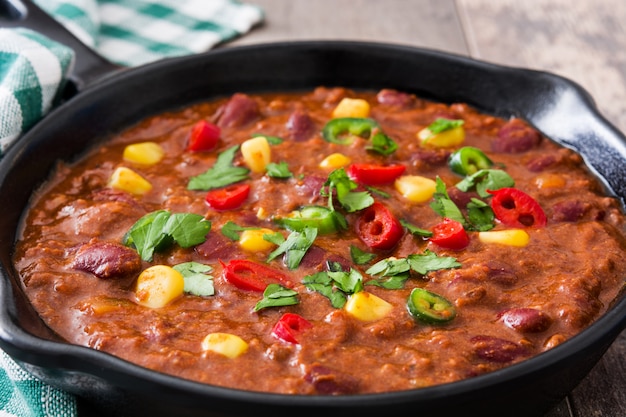 Traditionnel mexicain tex mex chili con carne dans une poêle sur table en bois se bouchent