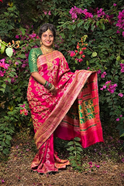 Traditionnelle indienne Belle jeune fille en saree posant à l'extérieur du parc