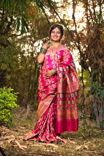 Traditionnelle indienne Belle jeune fille en saree posant à l'extérieur du parc