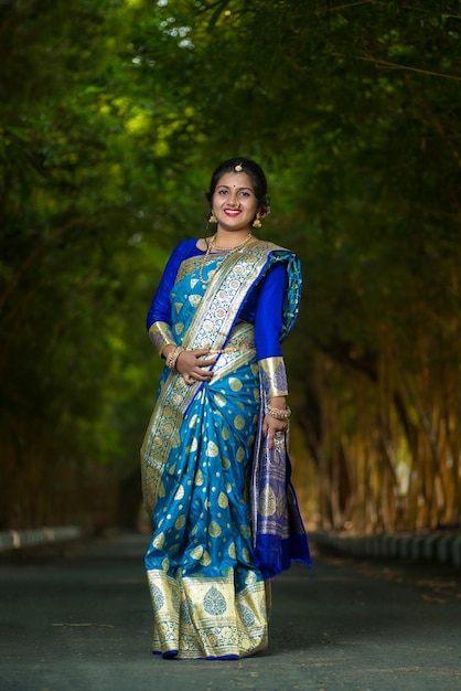 Traditionnelle indienne Belle jeune fille en saree posant à l'extérieur du parc