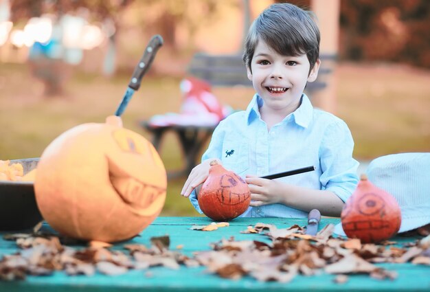 Traditions d'automne et préparatifs de la fête d'Halloween. Une maison dans la nature, une lampe faite de citrouilles se découpe à table.