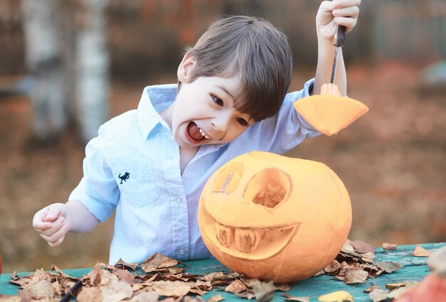 Traditions d'automne et préparatifs de la fête d'Halloween. Une maison dans la nature, une lampe faite de citrouilles se découpe à table.