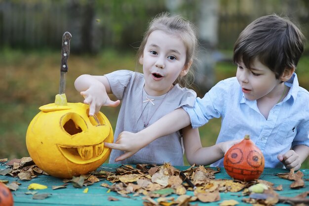 Traditions d'automne et préparatifs de la fête d'Halloween. Une maison dans la nature, une lampe faite de citrouilles se découpe à table.