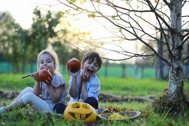 Traditions d'automne et préparatifs de la fête d'Halloween. Une maison dans la nature, une lampe faite de citrouilles se découpe à table.