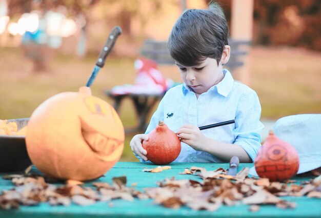 Traditions d'automne et préparatifs de la fête d'Halloween. Une maison dans la nature, une lampe faite de citrouilles se découpe à table.