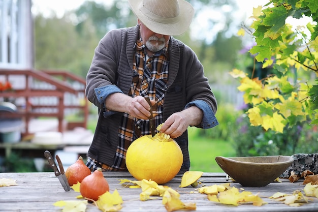 Traditions d'automne et préparatifs de la fête d'Halloween. Une maison dans la nature, une lampe faite de citrouilles se découpe à table.