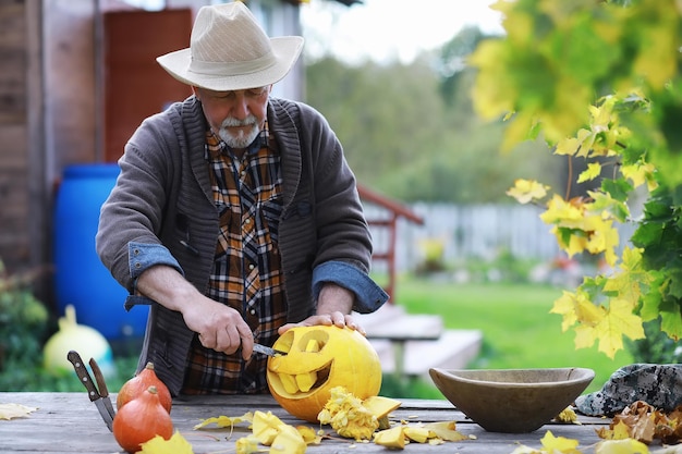 Traditions d'automne et préparatifs pour les vacances Halloween Une maison dans la nature une lampe faite de citrouilles se coupe à la table