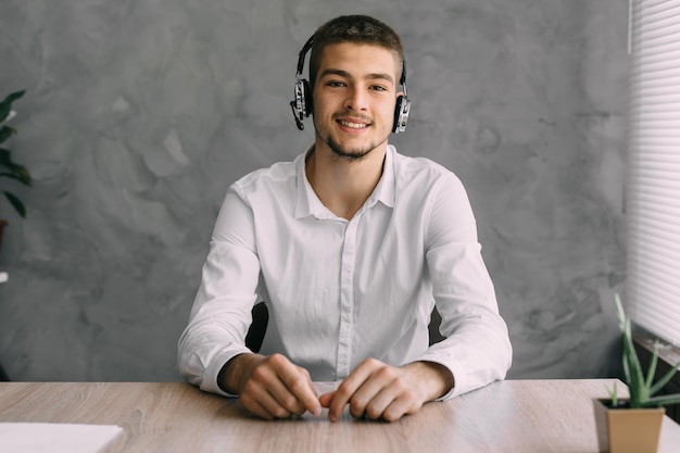Traducteur étranger souriant travaillant au bureau à domicile à l'aide d'un casque sans fil Opérateur de support en ligne Entretien sur le Web Recherche d'emploi Chat sur Internet Concept de travail et d'éducation à distance