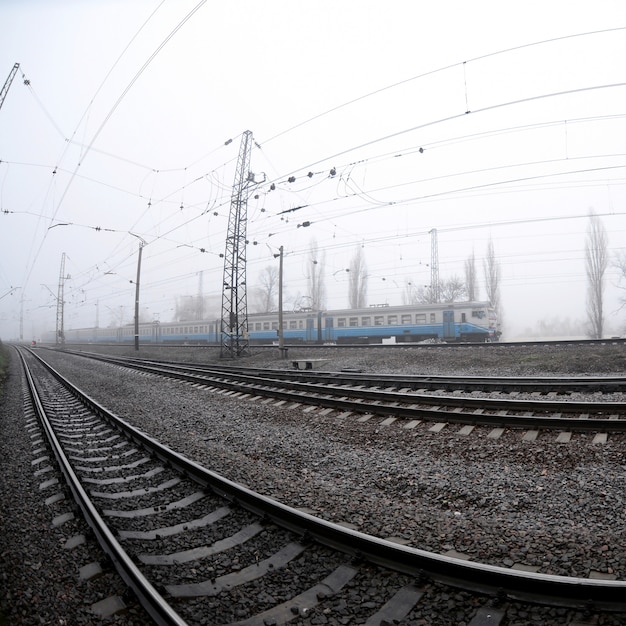 Le train de banlieue ukrainienne se précipite le long de la voie ferrée par un matin brumeux. Fisheye photo avec distorsion accrue