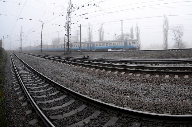 Le train de banlieue ukrainienne se précipite le long de la voie ferrée par un matin brumeux.