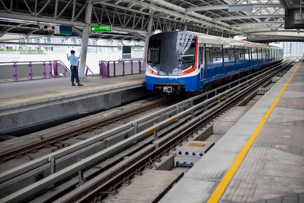 Train électrique et sécurité retour tenant la main à la gare en Thaïlande