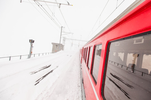 Un train rouge au milieu d'un désert de neige