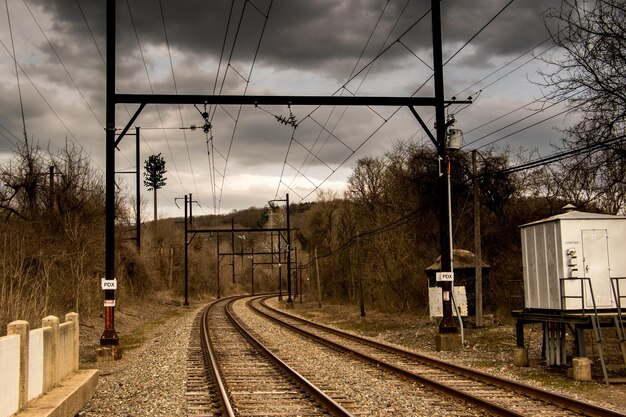 Le train sur les voies ferrées contre un ciel nuageux