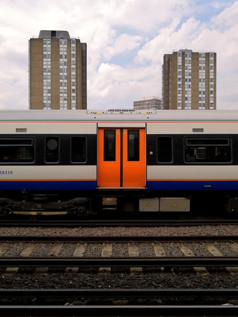 Photo le train sur les voies ferrées de la ville contre un ciel nuageux