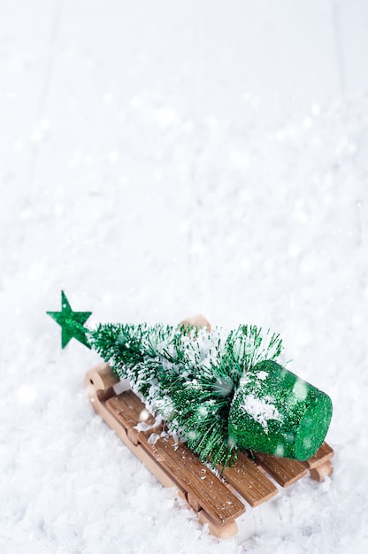 Traîneau d&#39;hiver en bois portant un petit sapin de Noël