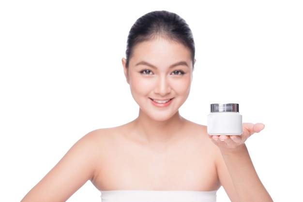 Traitement de beauté. Femme asiatique tenant une boîte de crème hydratante.