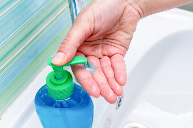 Photo traitement des mains avec du savon et des désinfectants désinfectants de gros plan de distributeur